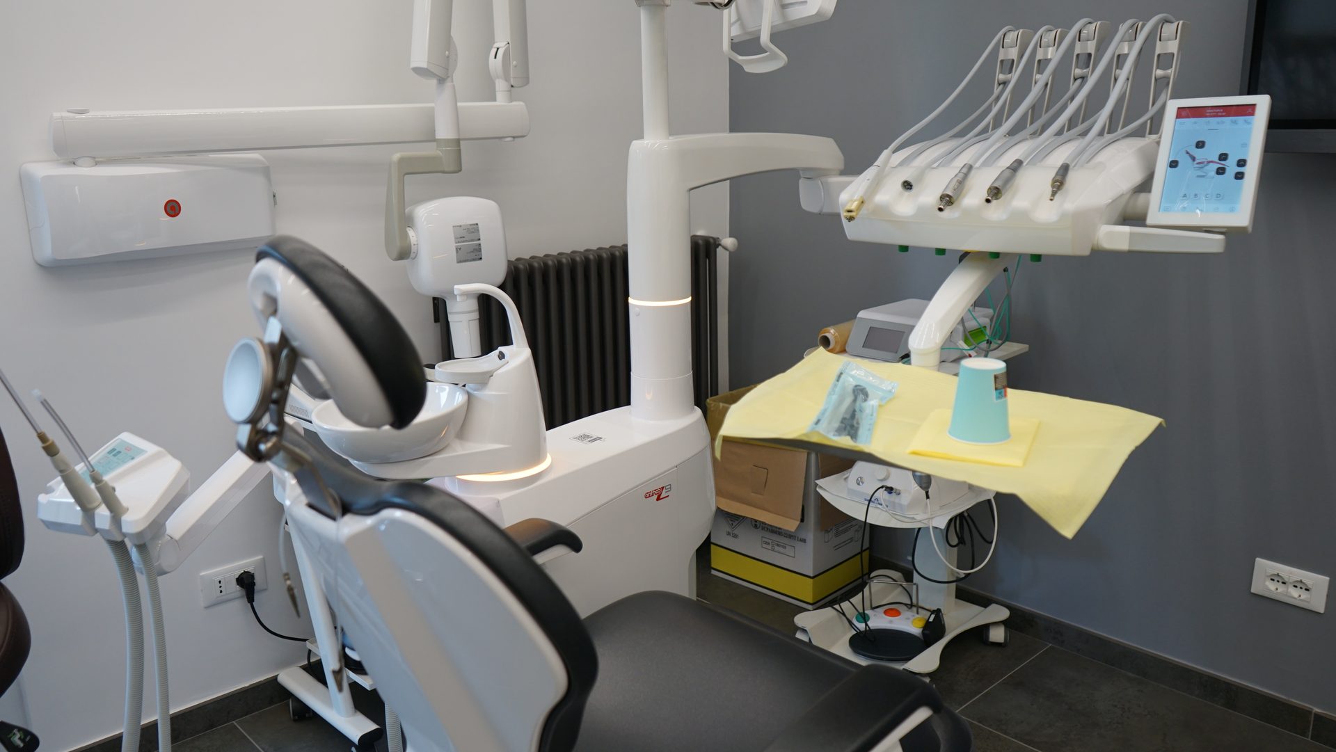 Riunito odontoiatrico bianco con strumenti pronti nella sala operativa