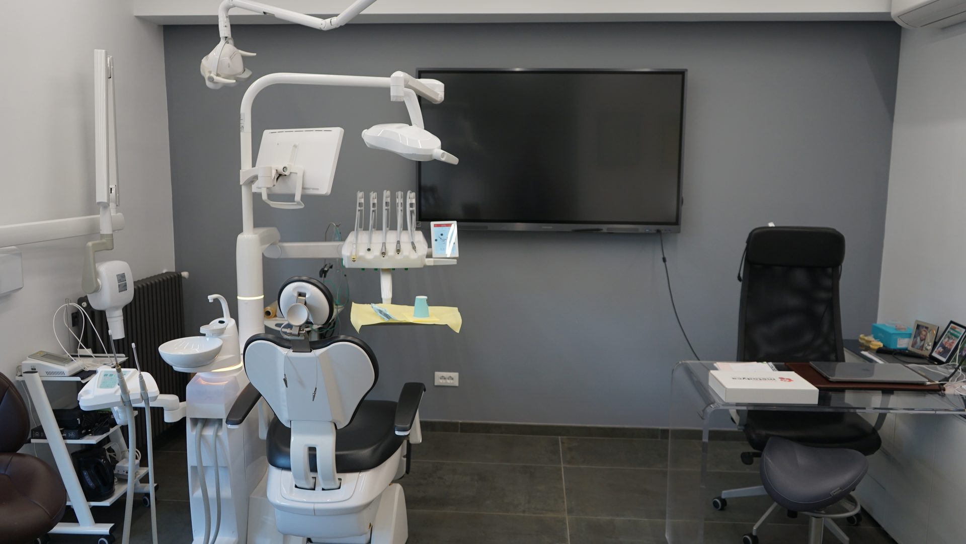 Riunito odontoiatrico con monitor a parete nella sala operativa